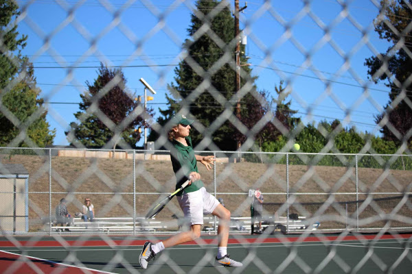 A Shorecrest tennis player aims to hit the ball in the midst of competition.