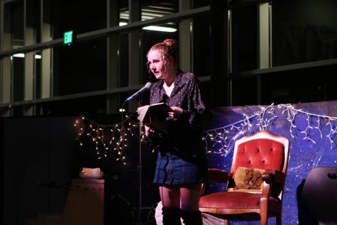 Editor Haley Larson stands reading one of her poems at the microphone of Tattoo’s Coffeehouse.