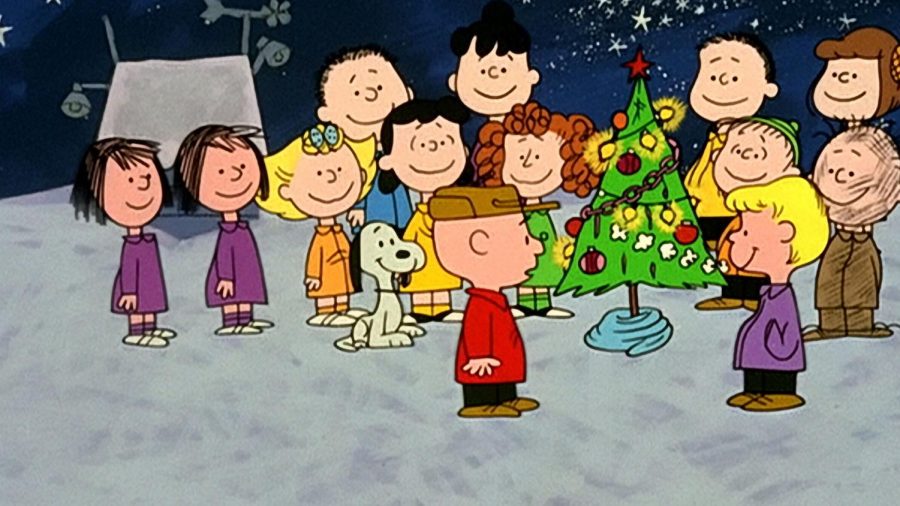 Charlie Brown and friends sing around the Christmas tree. 