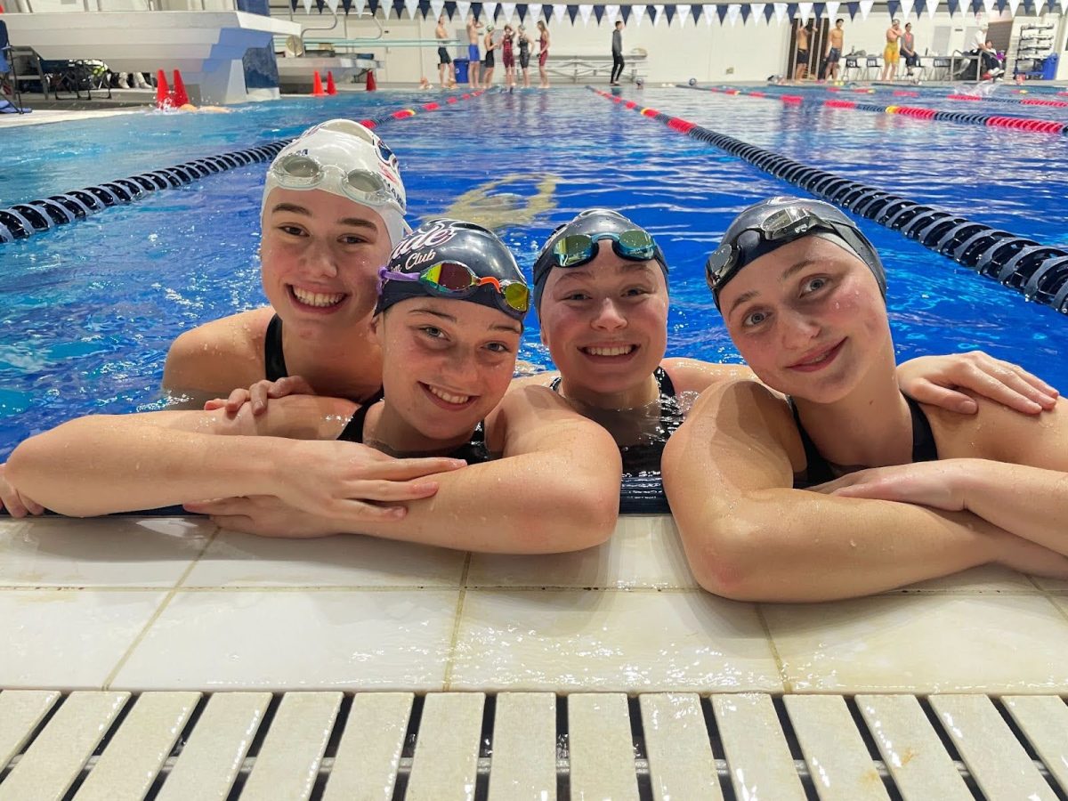 Miranda Thompson with three of her club teammates at a swim meet.